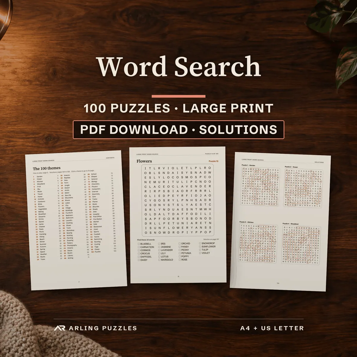 Large print word search book, 100 puzzles, PDF download with solutions. Real pages laid on a wooden desk by a warm blanket: the theme list, a puzzle and solutions.